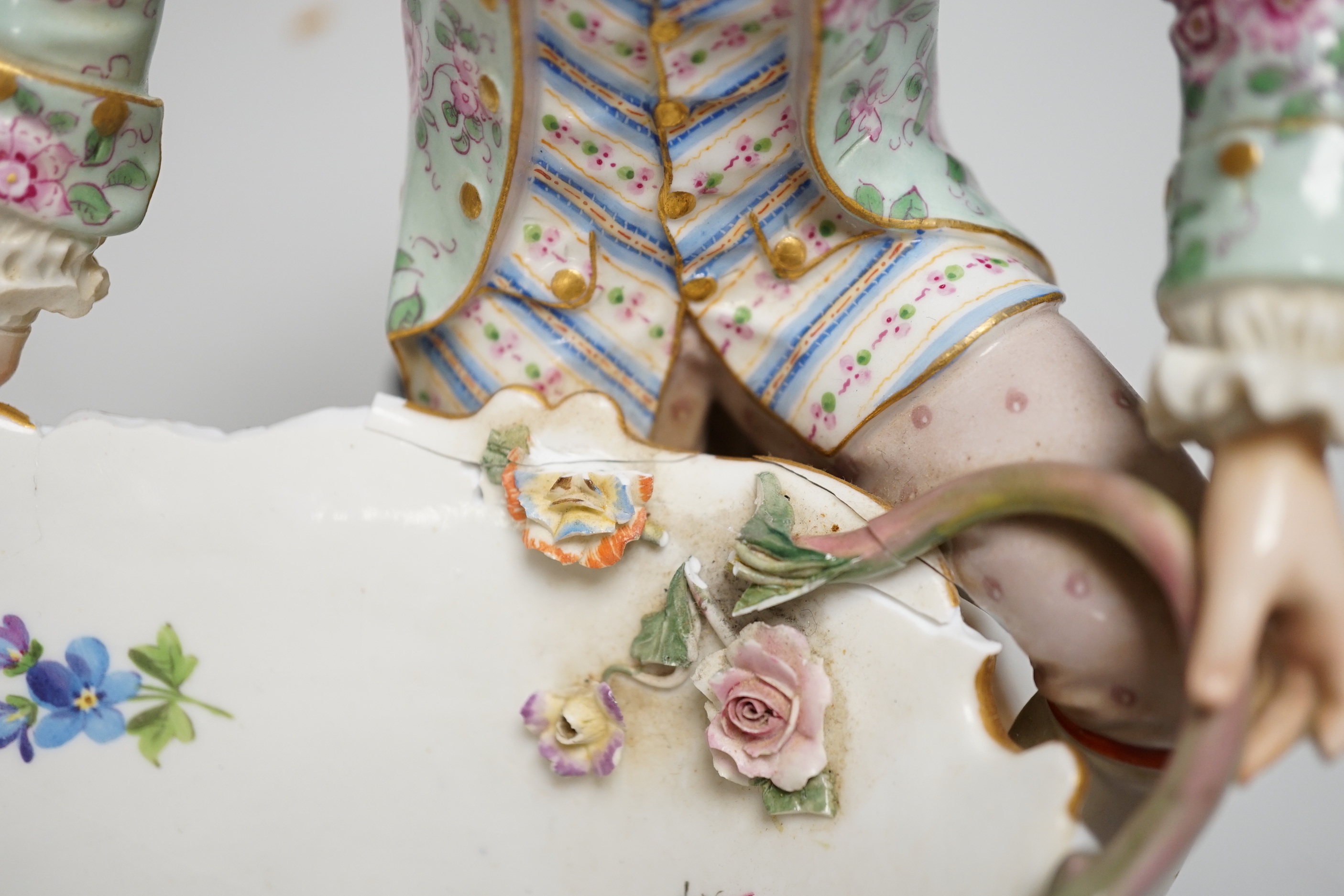 A large pair of Meissen salts in the form of a seated man and a woman in 18th century dress (a.f.), 21cm high